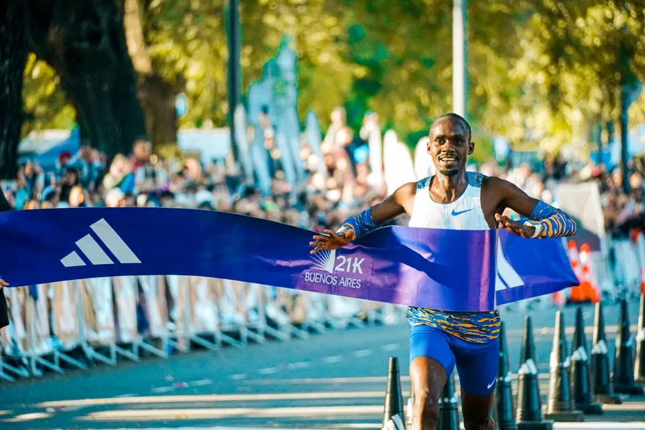 Des coureurs s'élancent au départ d'un semi-marathon urbain à l'étranger, dossards et maillots colorés